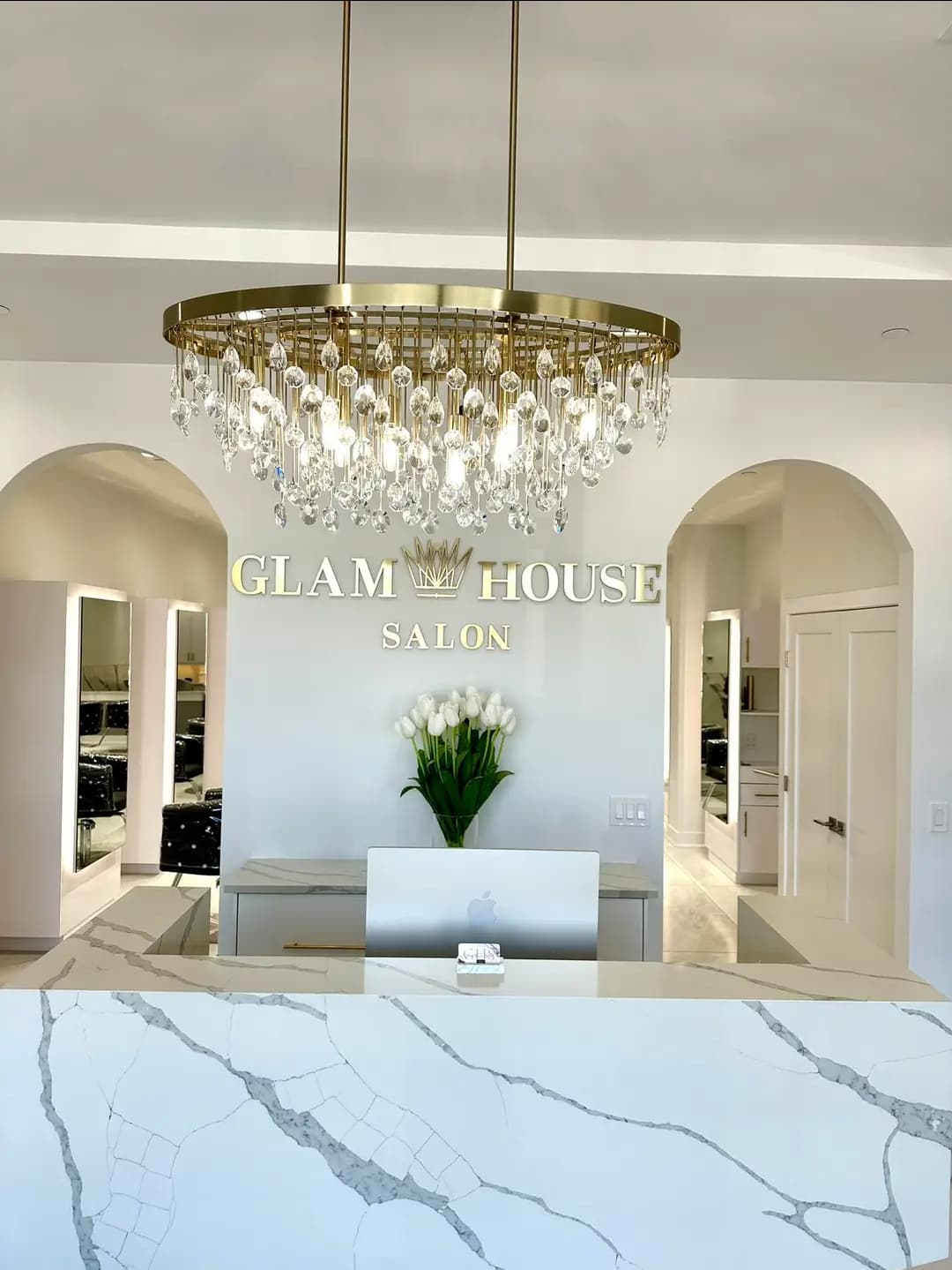 Glam House Salon interior — gold sign, crystal chandelier, marble reception